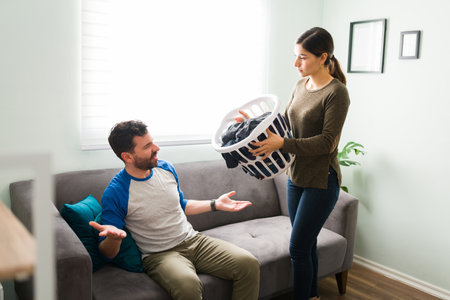 Angry girlfriend having an argument and demanding some help with house chores and laundry at home