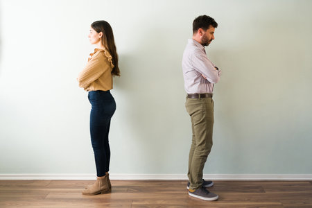 Latin young woman and man in his 30s with their backs turned and with an angry expression. Married...