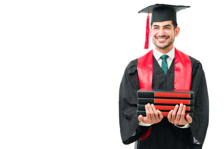 Latin young student graduating from Law School and holding a lot of academic books. Smart happy...