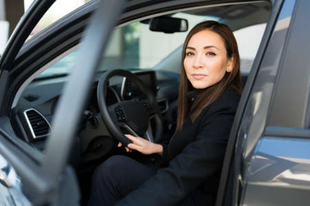 Portrait of a serious and professional businesswoman getting into her car to go to the office and a work appointment in the cityの写真素材