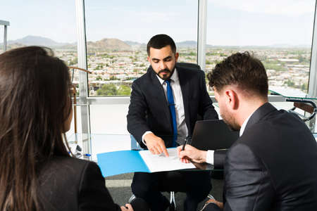 Successful male executive in a suit making a new business deal with two business partners. Lawyer...