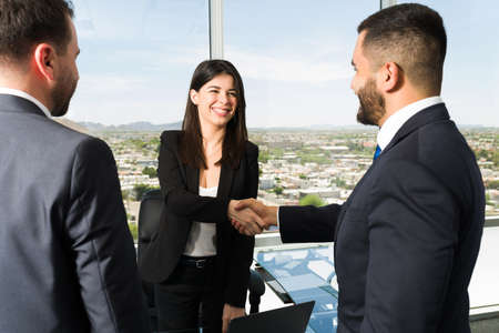 Happy to do business with you. Smiling businesswoman in a suit shaking hands with a sales...