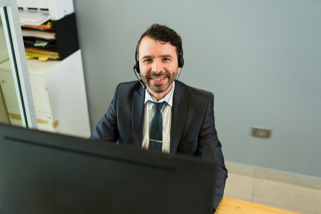 Sales representative feeling happy at work. Attractive hispanic executive with a headset taking...