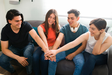 We will be friends forever. Attractive college friends putting their hands together and having a fun...