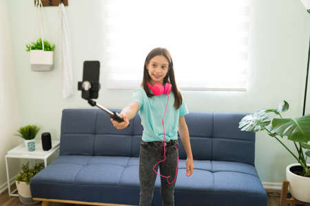 Shooting a lifestyle video at home for my followers. Happy caucasian girl taking a picture with a...
