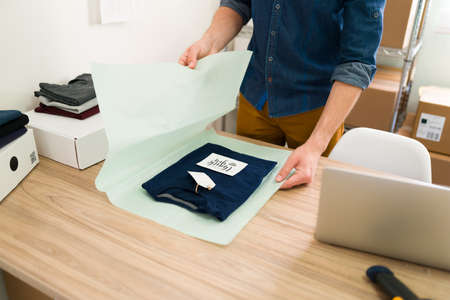 Thankful for your online purchase. Happy business owner putting a thank-you note on a package before...
