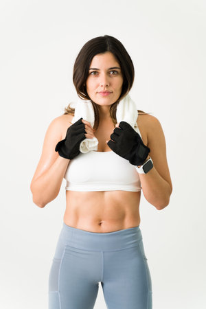 Excellent results at the gym. Strong young woman with toned abs finishing a workout at the gym and...