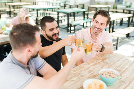 Finally together. Handsome young man making a toast with his best friends and celebrating at a bar....