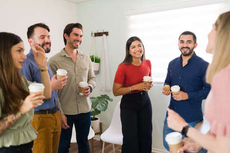 Cheerful young men and women laughing and having a great time during a coffee break. Members of a support group hanging out after their AA meetingの写真素材