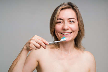 Dental hygiene concept. Portrait of a gorgeous mature woman in her 50s smiling before brushing her...