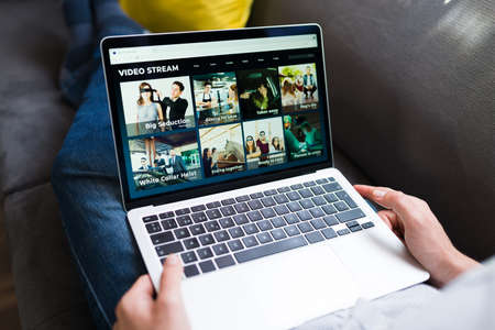 Relaxing with movies. Adult man looking for a movie or series on an online streaming serviceの写真素材