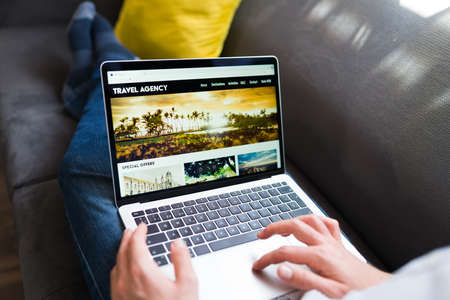 Online travel agency. Young person booking vacations for the holiday on the laptopの写真素材
