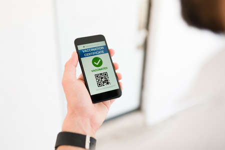 Health passport. Adult man searching for his online vaccination certificate on the smartphone