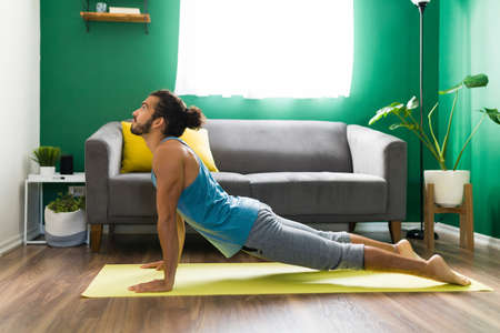 Good-looking man in a upward dog pose. Hispanic man enjoying a yoga workoutの写真素材