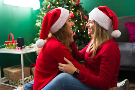 I want to be with you always. Couple in love sitting face to face and sharing positive emotions during Christmasの写真素材