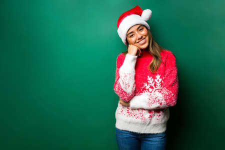 Thinking about Christmas. Beautiful woman with a santa hat using planning a holiday partyの写真素材