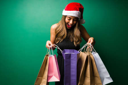 I can't believe I got so many presents. Gorgeous woman receiving a lot of Christmas presentsの写真素材