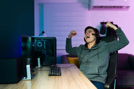 Excited caucasian gamer screaming with happiness after defeating and winning a video game competitionの写真素材