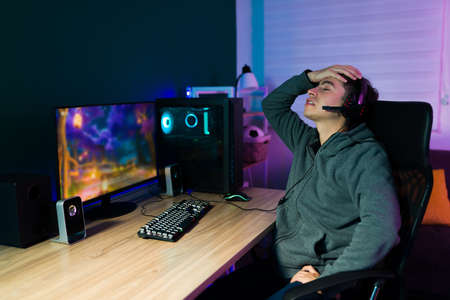 I can't believe I was defeated. Upset male gamer losing a video game competition and feeling angryの写真素材