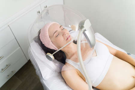 Reducing stress. Tired young woman on a massage table getting an anti-stress treatment with relaxing musicの写真素材