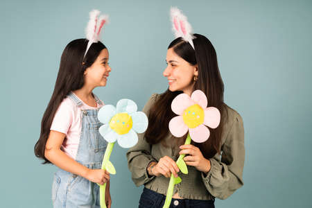 Spring is here. Lovely young mom and cute little girl with bunny ears excited for Easter