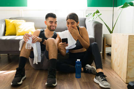 Looking at social media. Excited young woman laughing while showing a picture in the phone to her...
