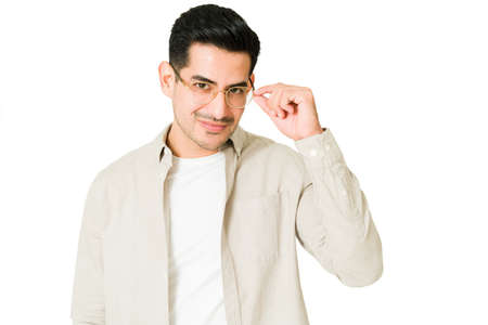 Flirty man in his 20s putting on  of a new glasses. Good-looking man buying stylish eyewear