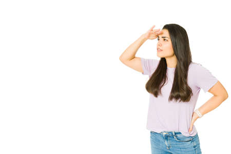 Looking into the horizon. Beautiful caucasian woman trying to see far away and searching for something in the distanceの写真素材