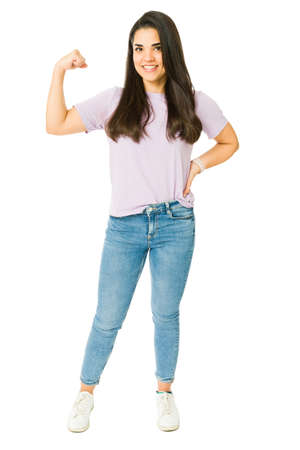 Full length of a gorgeous strong woman flexing her bicep while feeling powerful and capable