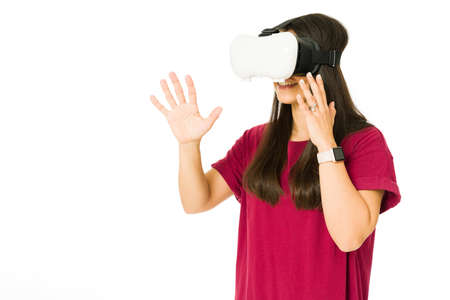Cheerful woman using a virtual reality glasses and playing a video game. Young woman playing and...