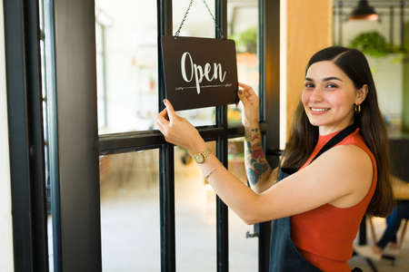 Attractive business owner opening her new restaurant and feeling proud of her workの写真素材