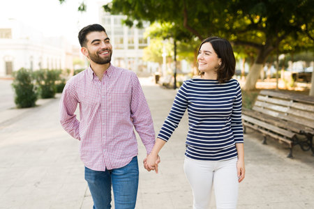 Excited caucasian couple in love laughing and holding hands while having the best time during a date
