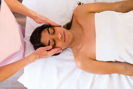 Relaxed young woman going to the beauty spa for a relaxing massage and a facial treatmentの写真素材