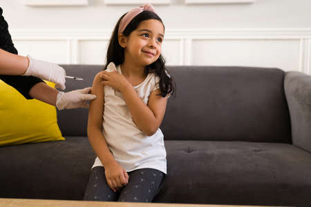Children's covid vaccine. Brave little girl smiling while getting her covid shot