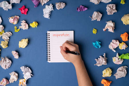 I have trouble thinking of new ideas. Creative caucasian adult feeling inspired and writing down original ideasの写真素材
