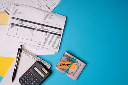 Taking care of personal finances. Invoices, bills, calculator and savings in cash to pay for taxesの写真素材