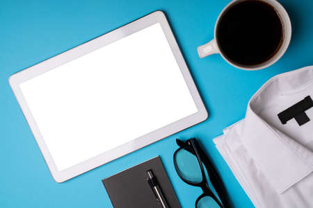 Ready to start working. Touchscreen tablet, cup of coffee, agenda, eyeglasses and formal shirt of a...