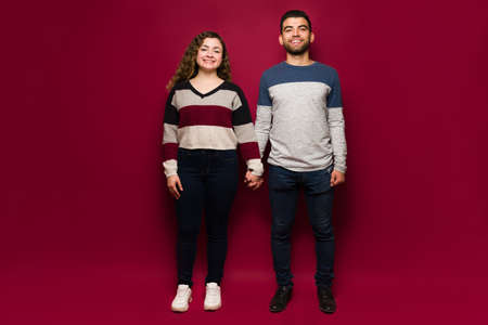 Portrait of a beautiful caucasian woman and hispanic man holding hands while enjoying each other's companyの写真素材