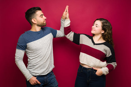 We are the best team! Cheerful young man and woman making a high five and celebrating their success