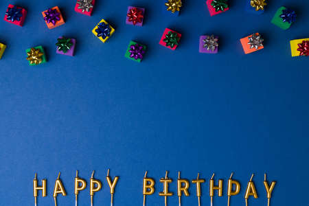Party concept. Many small  gifts boxes and gold candles ready to be lit to celebrate a birthday...