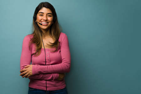 Customer support. Cheerful hispanic woman using a headset and working as a sales agent at a call...