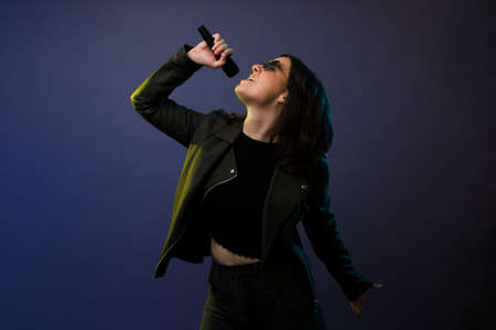 I love to sing. Passionate young woman singing and rehearsing for a rock concertの写真素材