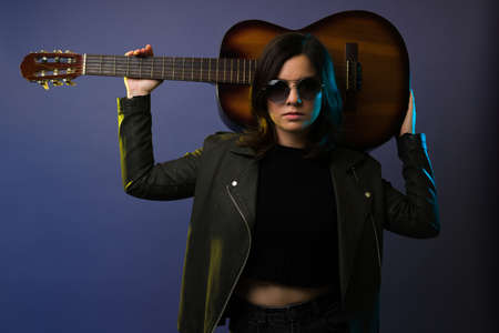 Beautiful young woman ready to sing and play the acoustic guitar on a rock concertの写真素材