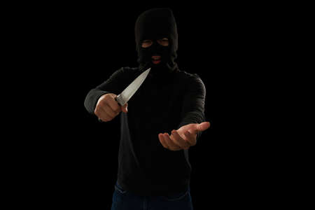 Armed robbery. Angry young thief pointing a knife to a victim and screaming while asking for money