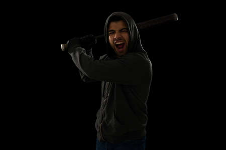 Violent hispanic thug using a baseball bat to hit a victim and screaming while looking at the camera