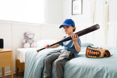 Talented kid preparing for baseball practice. Cute boy with a baseball bat dreaming of becoming a...