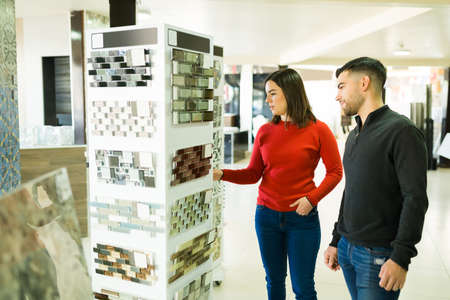 Handsome man and beautiful woman choosing together the tiles for their new remodel kitchenの写真素材