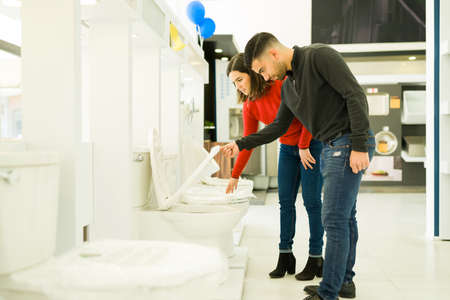 Caucasian young couple remodeling her bathroom and buying toilets at the furniture storeの写真素材