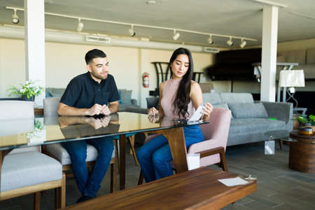 Sale prices. Happy couple shopping together new furniture for their new house at a showroom storeの写真素材