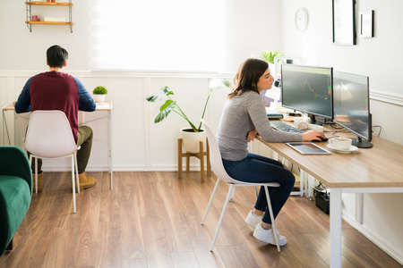 Tired young woman and man at the office working on the computer. Bored brokers in the stock market...
